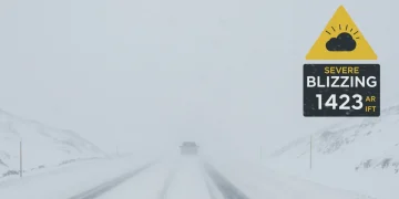 Severe blizzard warning on a digital screen over a snow-covered road
