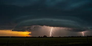 Supercell thunderstorm over rural landscape with lightning